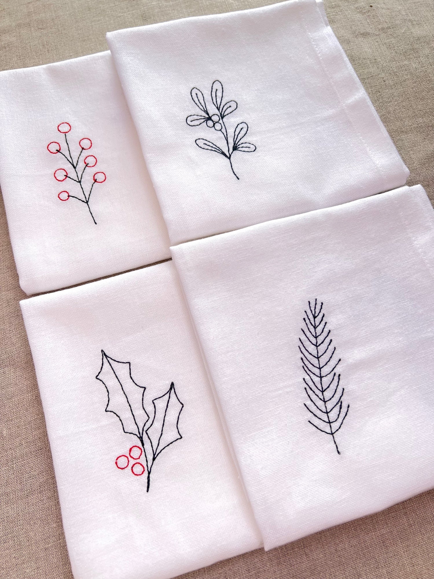 Set of four embroidered Christmas napkins – holly, mistletoe, berries, and fir