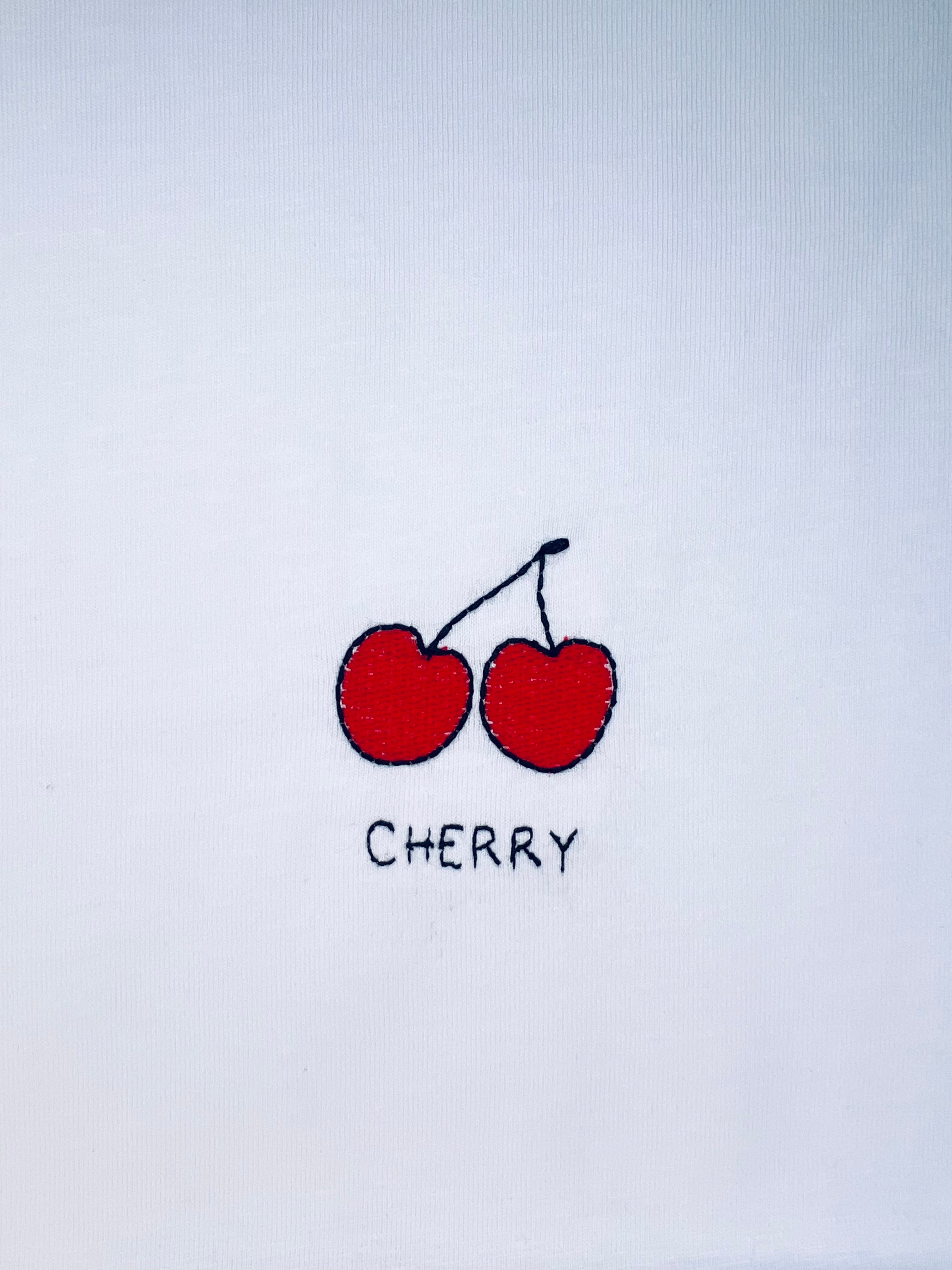 Cherry embroidery motif on white T-shirt, customizable with personal name or word in cursive script