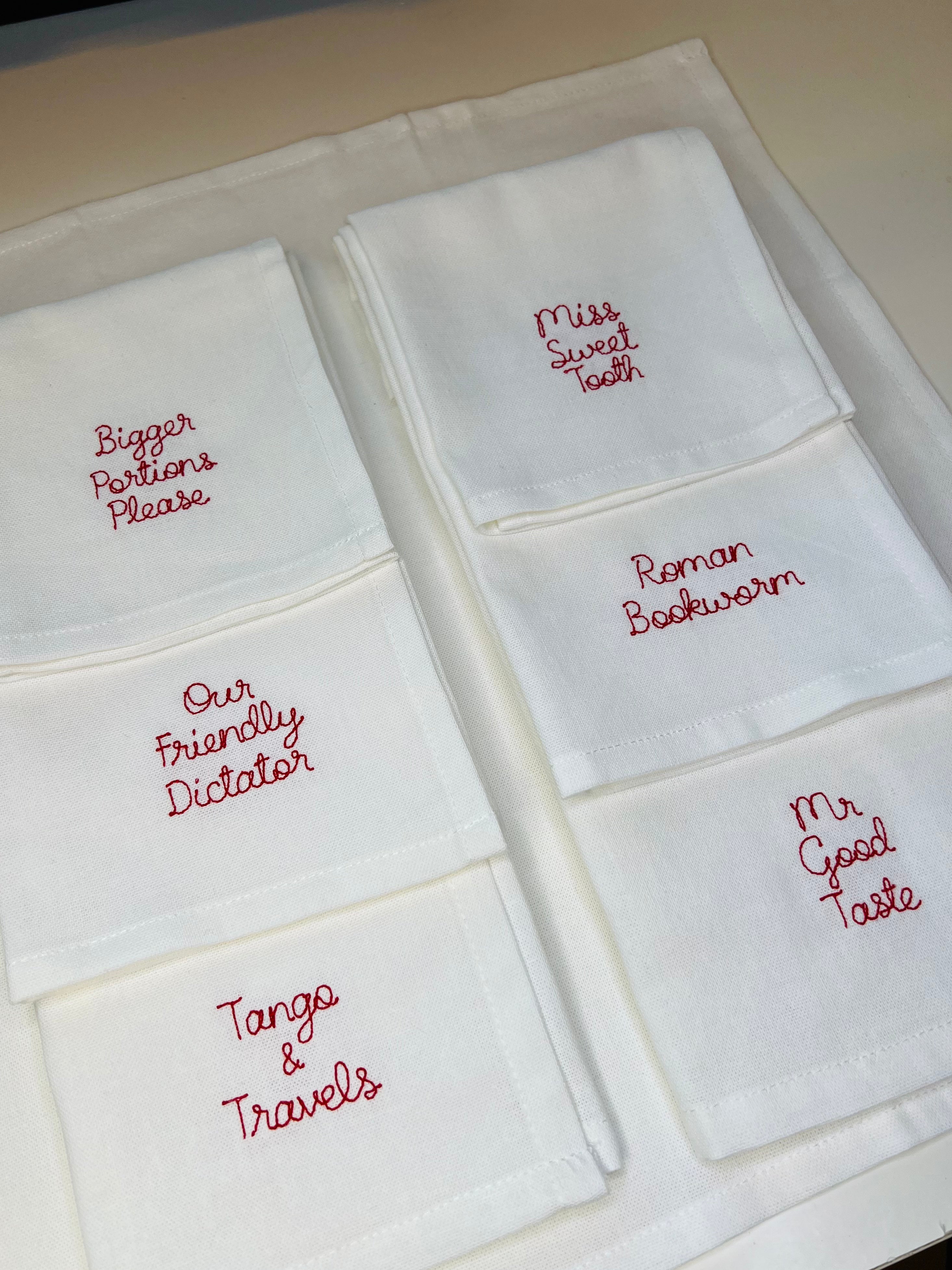 A set of custom embroidered napkins with red thread for family table