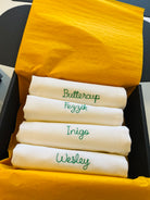 Bespoke embroidered cotton napkins featuring family nicknames in green thread