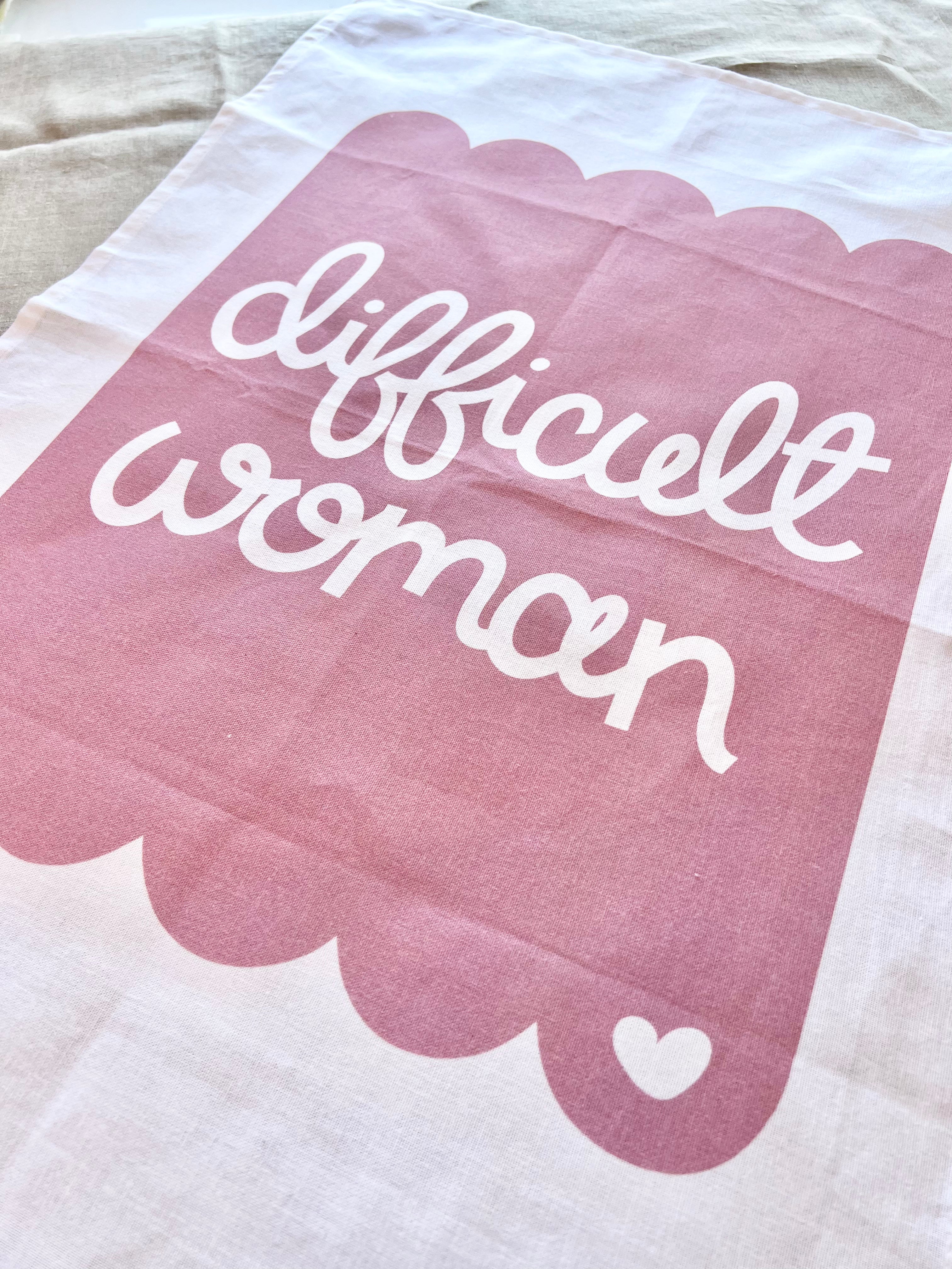 Cotton tea towel with pink scallop design and the words difficult woman