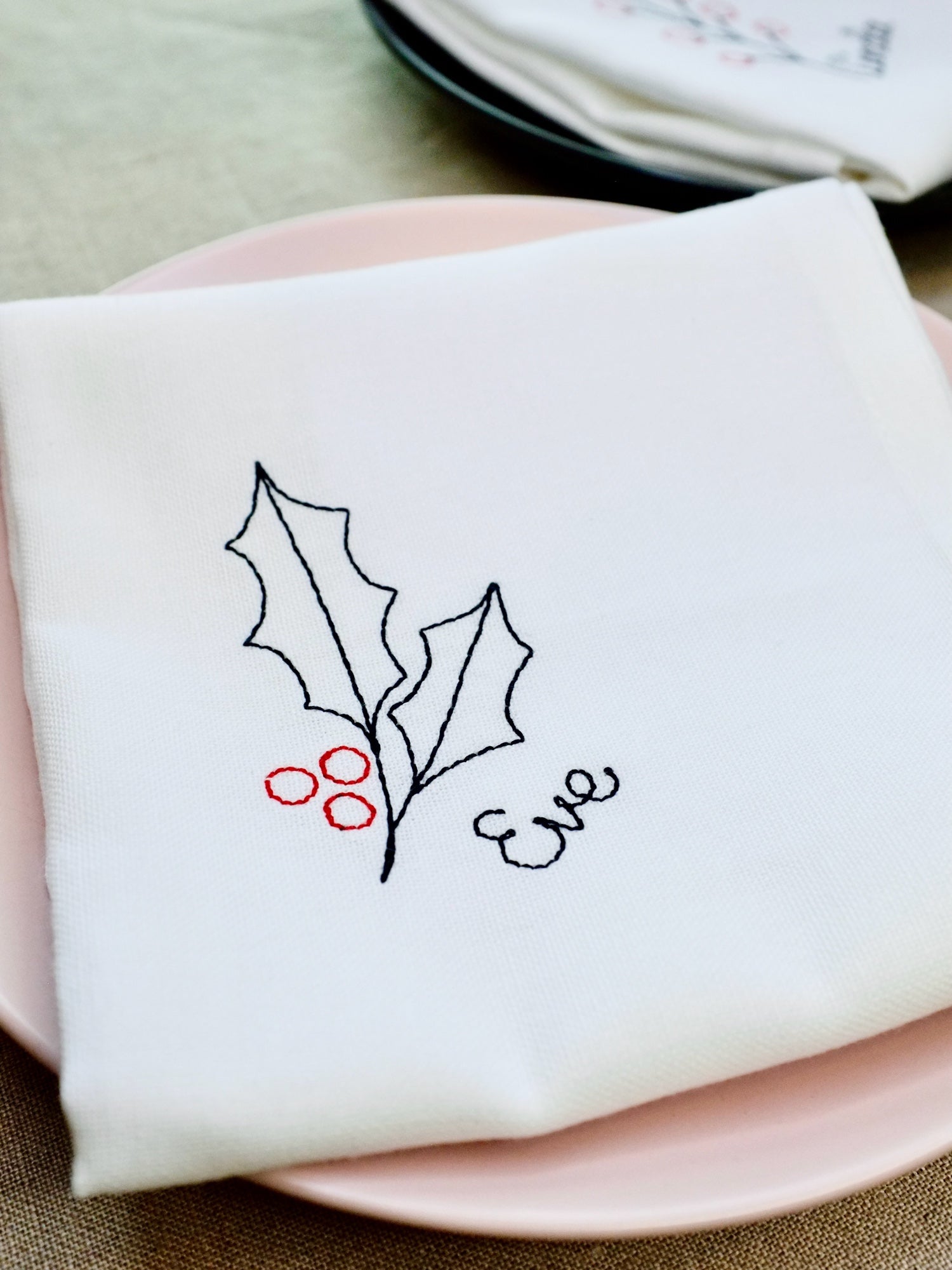 A festive cotton napkin embroidered with classic holly leaves and red berries, personalised with your chosen name. The perfect touch for Christmas dining, these stitched napkins work beautifully as both table décor and unique place cards.
