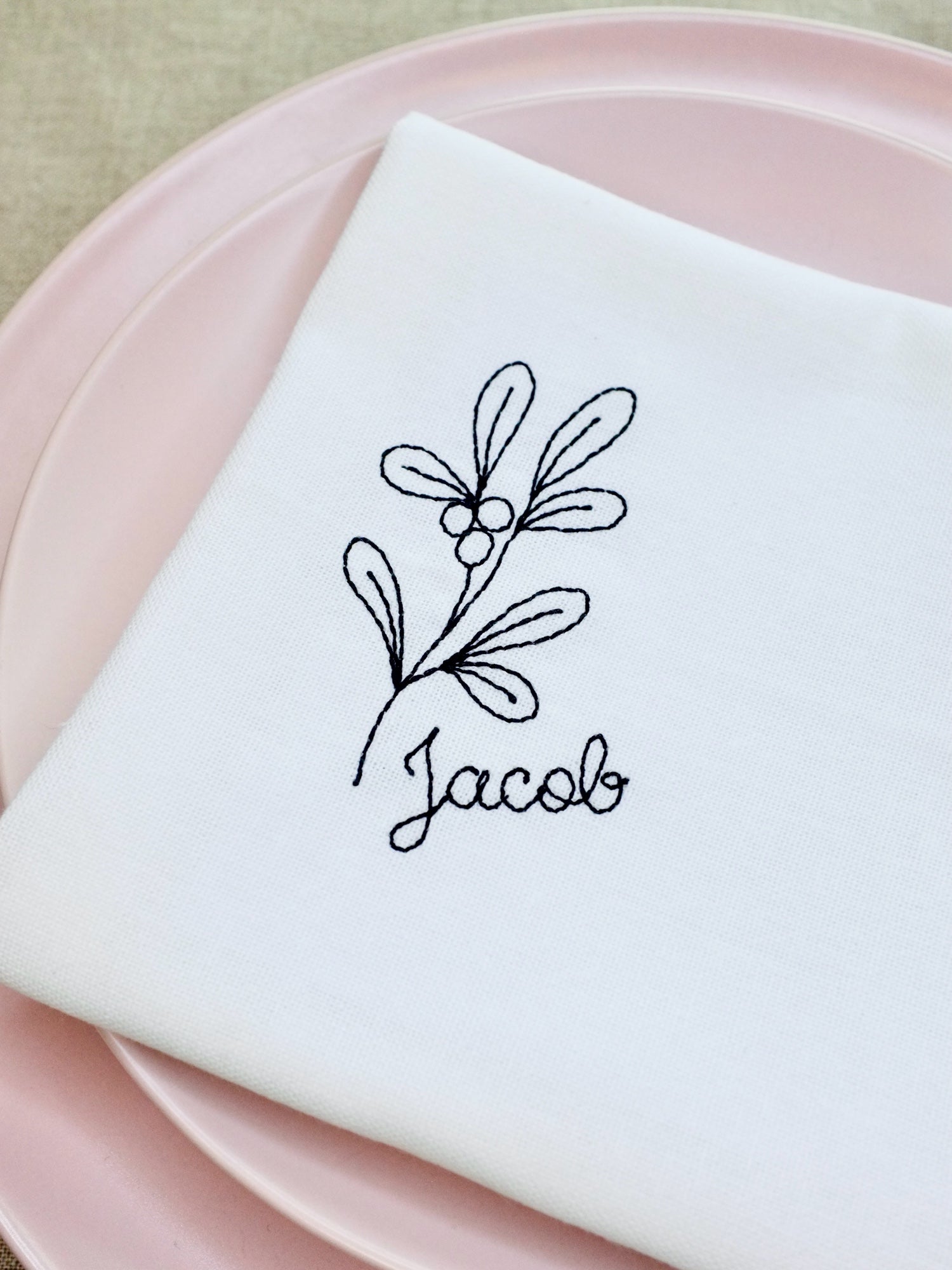 A beautiful cotton napkin featuring a delicate stitched botanical motif alongside your chosen name. Elegant and timeless, this embroidered napkin doubles as a place setting and keepsake, making it ideal for family gatherings, weddings, or Christmas tables