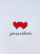 Two hearts embroidery motif on white T-shirt with custom names, perfect for personalized gifts and couples
