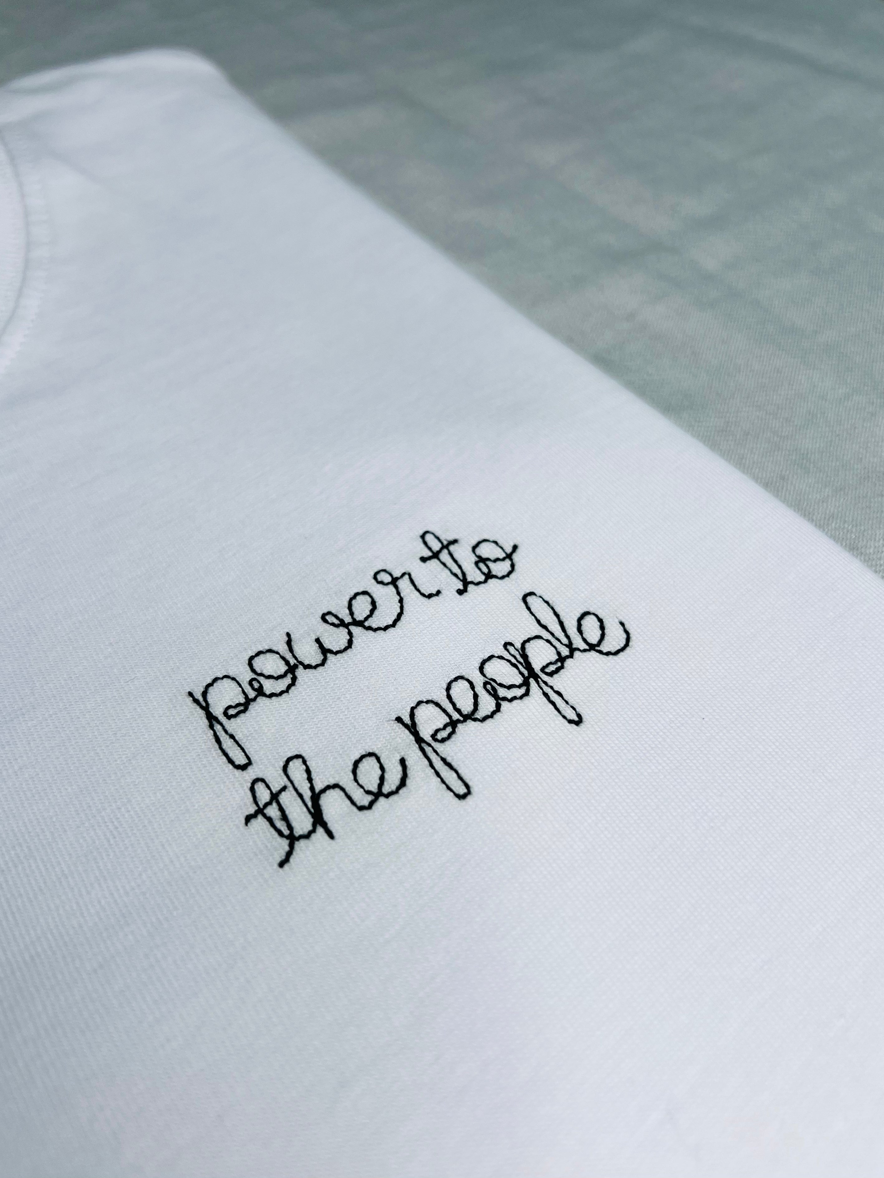 white t-shirt with 'power to the people' embroidered in black thread, custom bespoke slogan embroidery