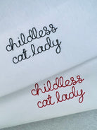 white t-shirt with 'childless cat lady' embroidered in black and red thread, custom bespoke slogan embroidery