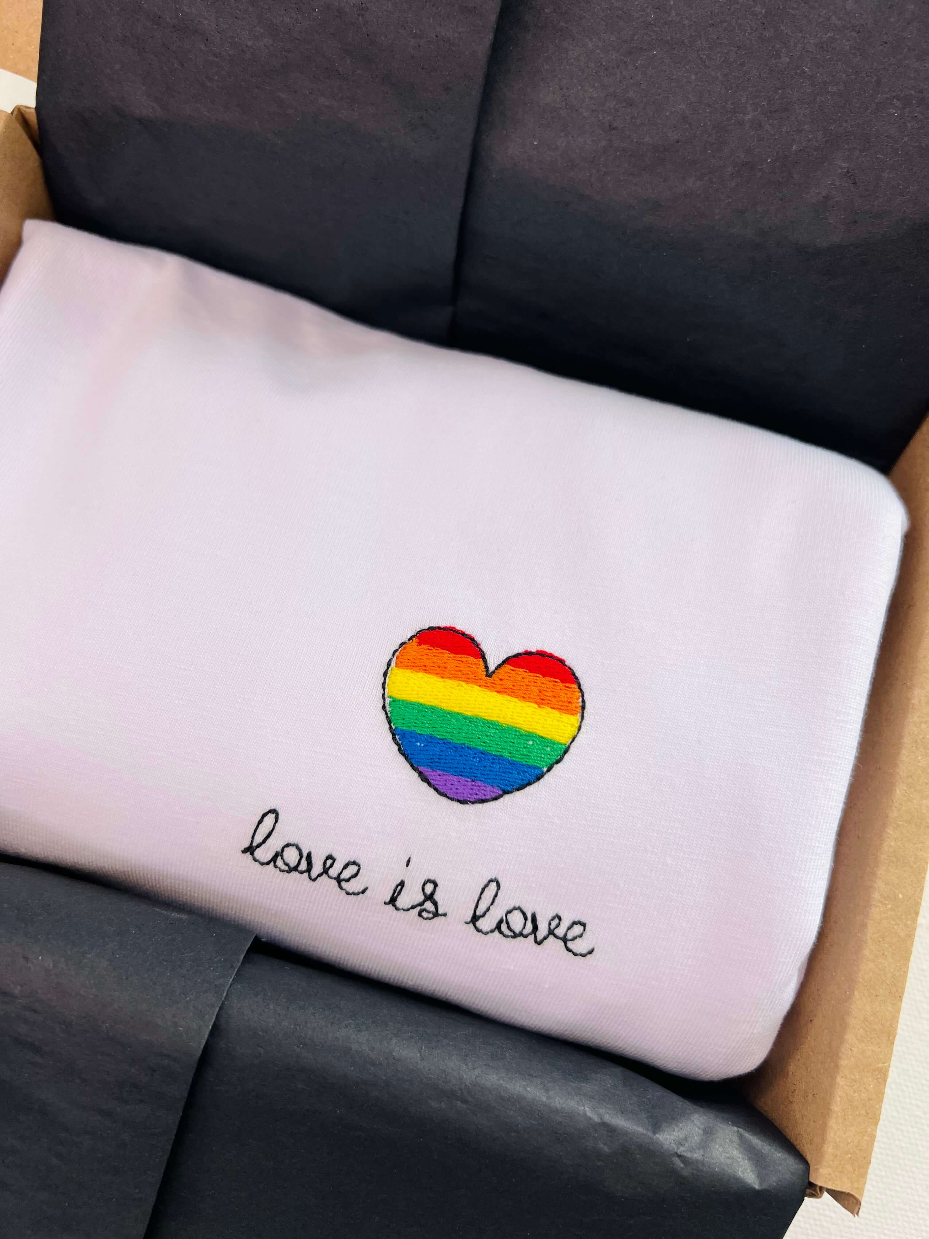Embroidered pride heart with ‘love is love’ on white cotton T-shirt