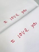 White tee with the words ‘I love you’ embroidered in red thread for a valentine’s gift custom handwriting 