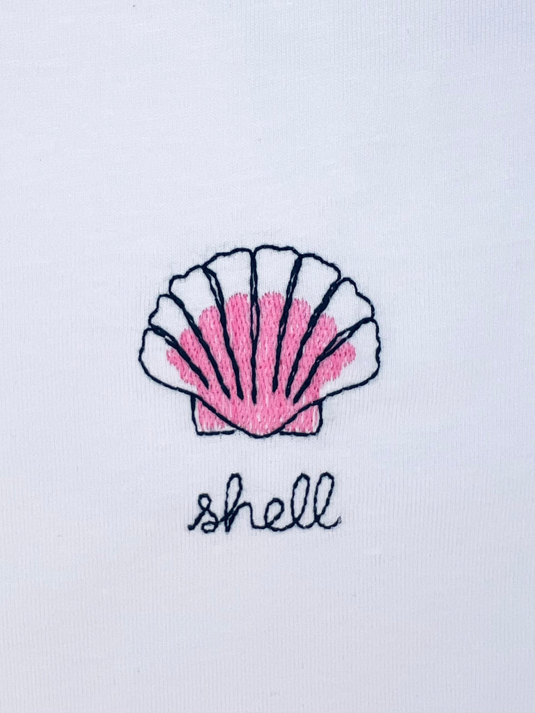 Shell embroidery motif on T-shirt with option to add custom name, perfect for beach lovers or coastal style